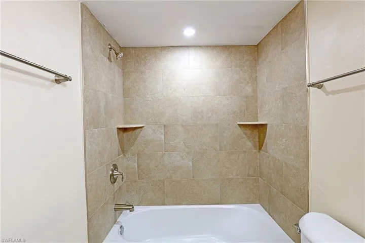 Full bathroom featuring washtub / shower combination and toilet