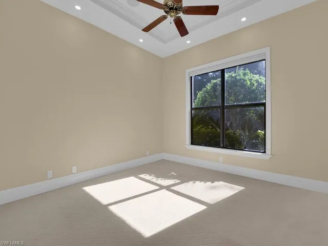 Carpeted empty room with ornamental molding, recessed lighting, a raised ceiling, and ceiling fan