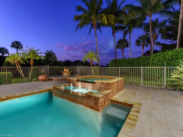 View of pool with a patio, a fenced backyard, and a pool with connected hot tub