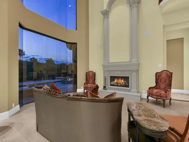Living area with a towering ceiling, a high end fireplace, and tile patterned flooring
