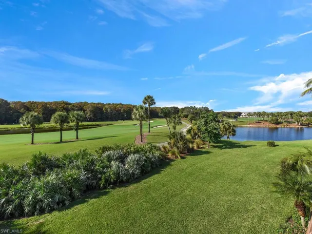 View of community featuring view of wooded area, view of golf course, a water view, and a yard