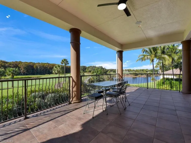 View of patio with ceiling fan, view of wooded area, a water view, and outdoor dining area