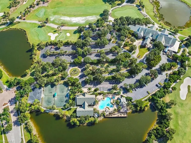 Aerial view of property and surrounding area with a nearby body of water and a golf club