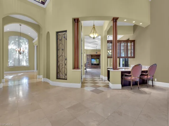 Foyer with a chandelier, recessed lighting, and ornate columns