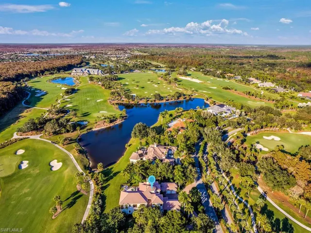 Aerial view of residential area featuring a local golf course and a large body of water