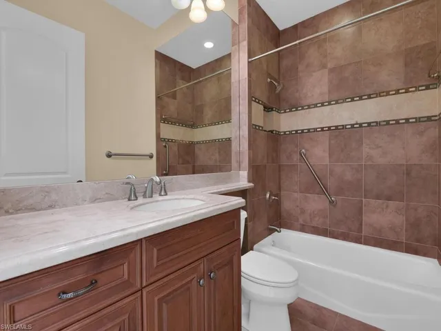 Bathroom with vanity, shower / tub combination, and tile patterned floors
