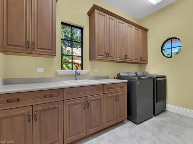 Washroom featuring cabinet space and independent washer and dryer