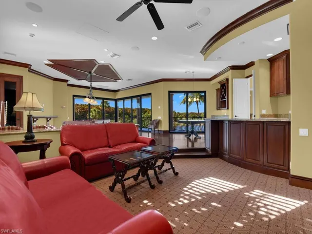 Living room with crown molding, light carpet, a chandelier, a ceiling fan, and recessed lighting