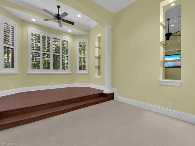 Spare room featuring decorative columns, ceiling fan, crown molding, recessed lighting, and arched walkways