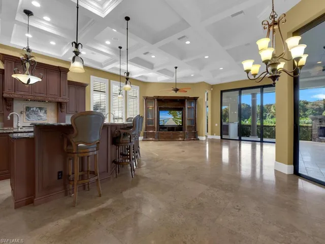 Bar area with hanging light fixtures, a ceiling fan, dark stone counters, coffered ceiling, and recessed lighting