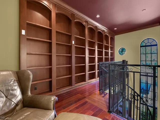 Sitting room featuring an upstairs landing, dark wood finished floors, recessed lighting, and built in features