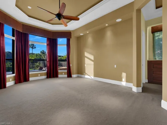 Master Bedroom with ornamental molding, ceiling fan, carpet, a tray ceiling, and recessed lighting