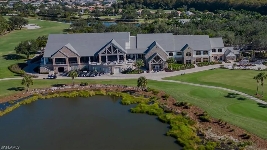 Drone / aerial view of a golf course and a nearby body of water