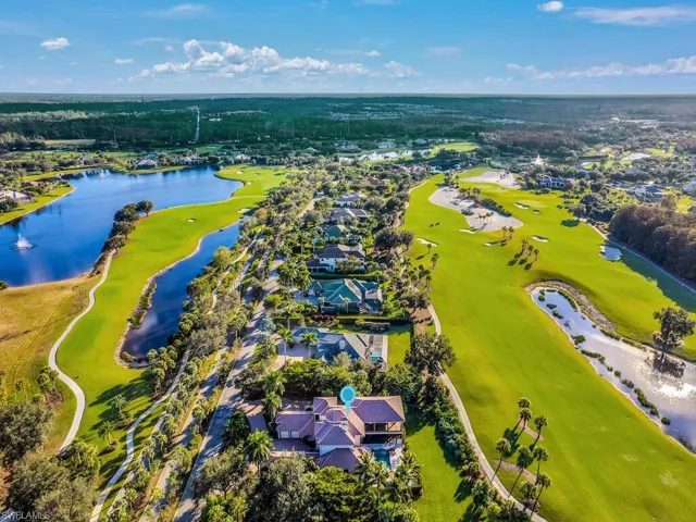Aerial perspective of suburban area with a large body of water and a golf course