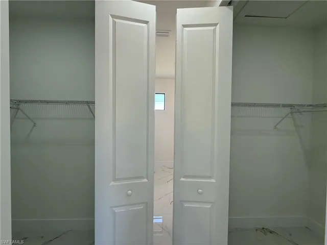 Walk in closet with marble finish floors