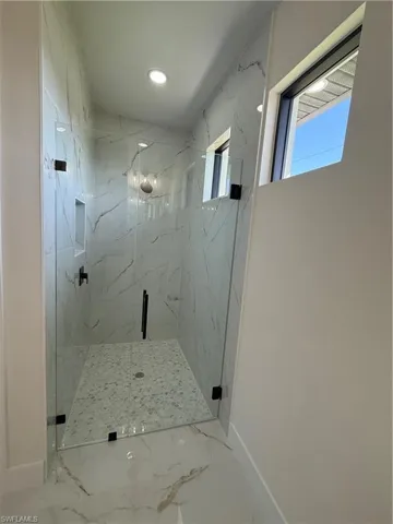 Full bathroom featuring a marble finish shower, marble finish flooring, and recessed lighting