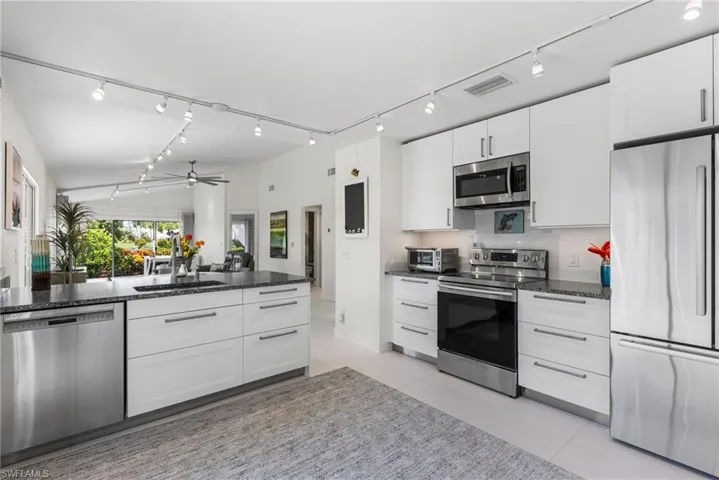 Open concept with white cabinetry, granite countertops, 24 x24 porcelain tile floors throughout, Track lighting, 5 inch base and new interior doors.