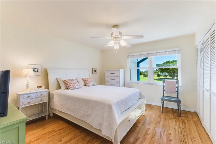 Bedroom with light wood-type flooring, a closet, and a ceiling fan