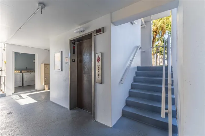 Staircase with washer and dryer, elevator, and concrete floors