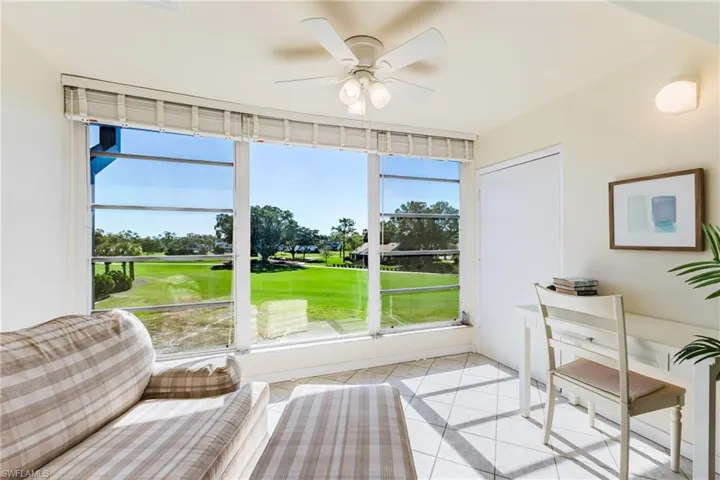 Sunroom with ceiling fan and golf course view
