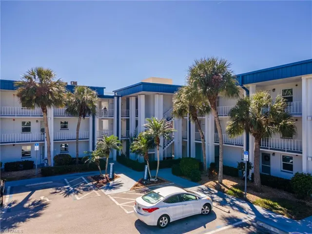 View of building exterior with uncovered parking