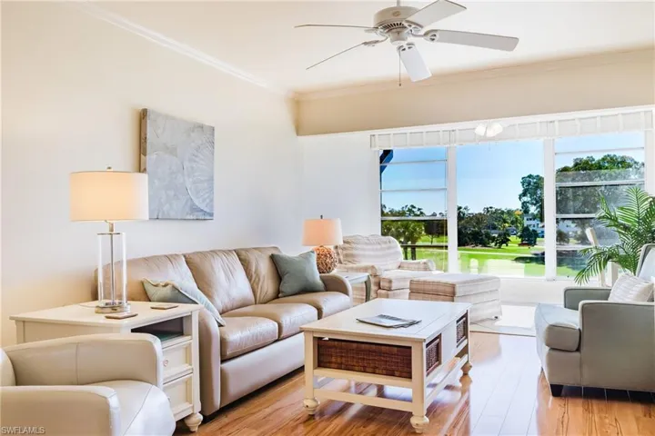 Living area with light wood-style flooring, a ceiling fan, and ornamental molding