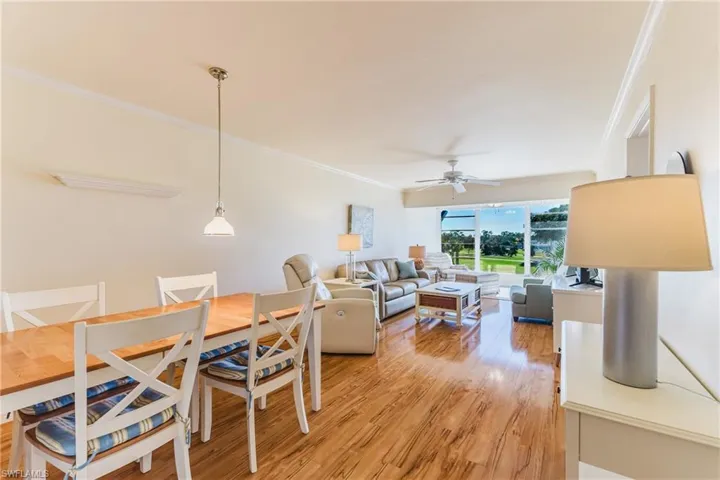 Dining room with crown molding, light wood-style floors, and a ceiling fan