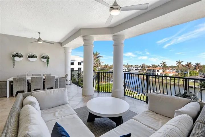 Balcony featuring ceiling fan, a water view, and an outdoor living space