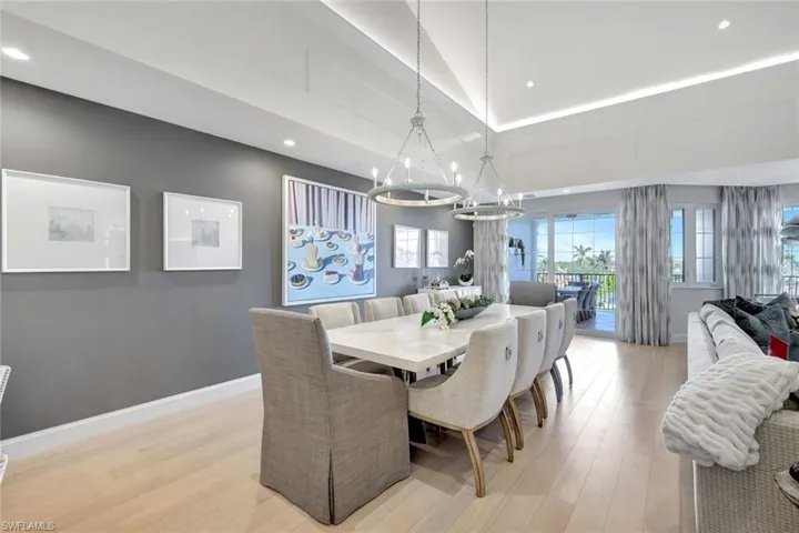 Dining space with vaulted ceiling, light wood-type flooring, and an inviting chandelier