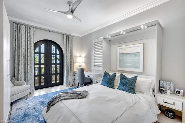 Bedroom with crown molding, ceiling fan, french doors, and light hardwood / wood-style floors