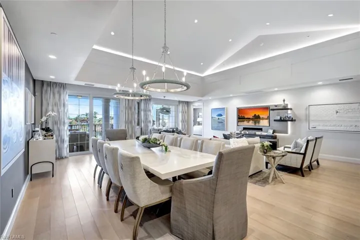 Dining room with a chandelier, light wood-type flooring, and lofted ceiling