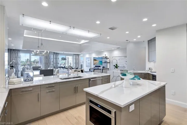 Kitchen featuring sink, gray cabinets, appliances with stainless steel finishes, a large island, and light hardwood / wood-style floors