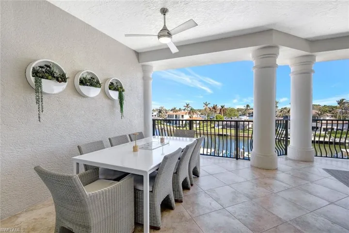 View of patio featuring a water view, ceiling fan, and a balcony