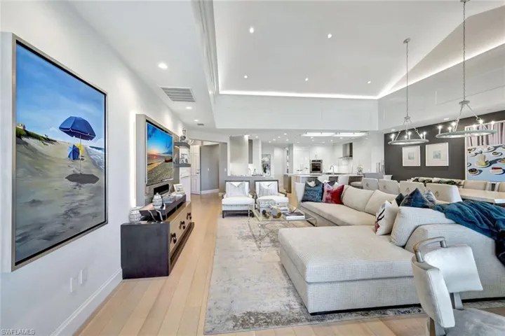 Living room with light hardwood / wood-style floors and vaulted ceiling