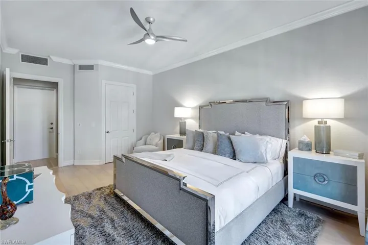 Bedroom with hardwood / wood-style floors, ceiling fan, and crown molding