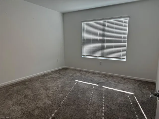 Unfurnished room with carpet floors and baseboards