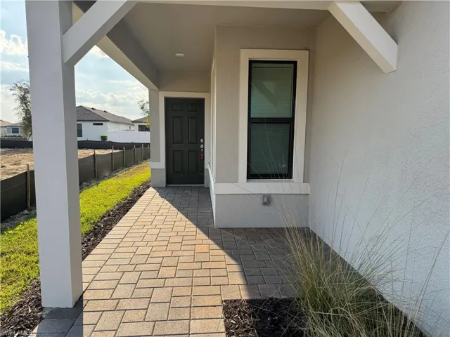 Doorway to property with stucco siding and a porch