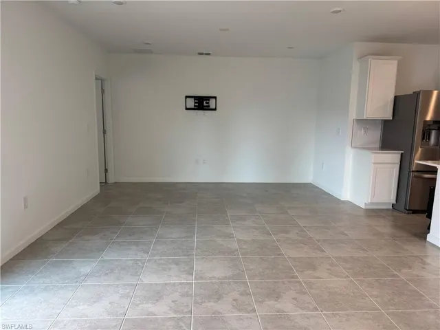 Unfurnished living room featuring baseboards and light tile patterned flooring