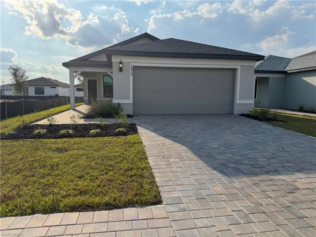 Single story home featuring stucco siding, decorative driveway, an attached garage, and a shingled roof