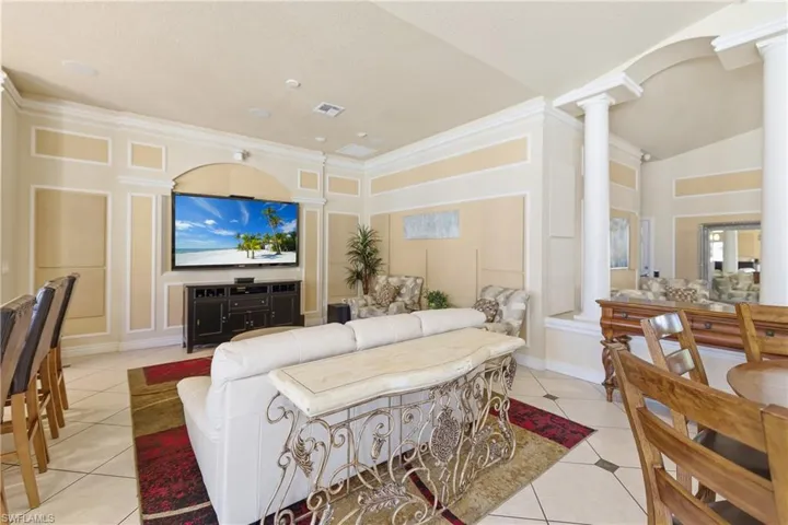 Living room featuring light tile patterned floors and crown molding