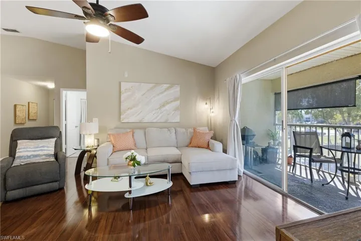 Living room with vaulted ceiling, hardwood / wood-style flooring, and ceiling fan