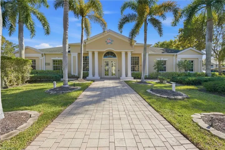 Greek revival house featuring french doors, a front lawn, and stucco siding