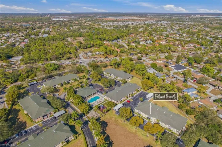 Aerial view of property and surrounding area featuring nearby suburban area
