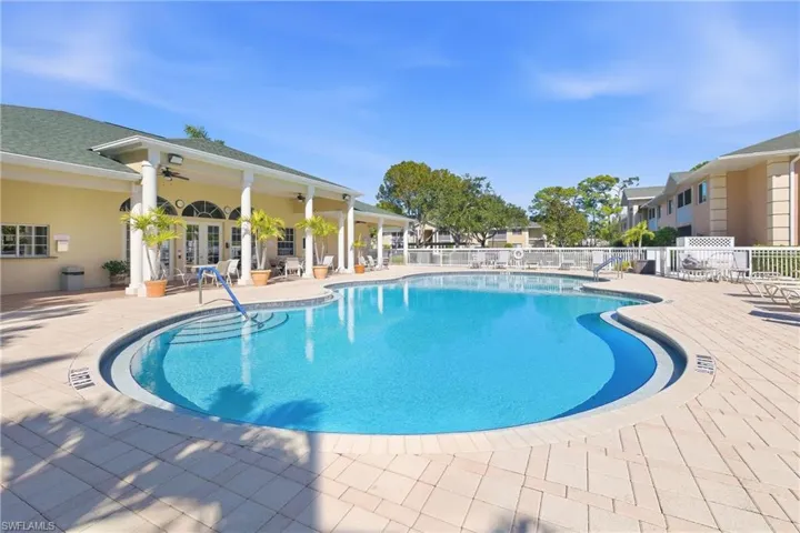 Community pool with a patio and french doors