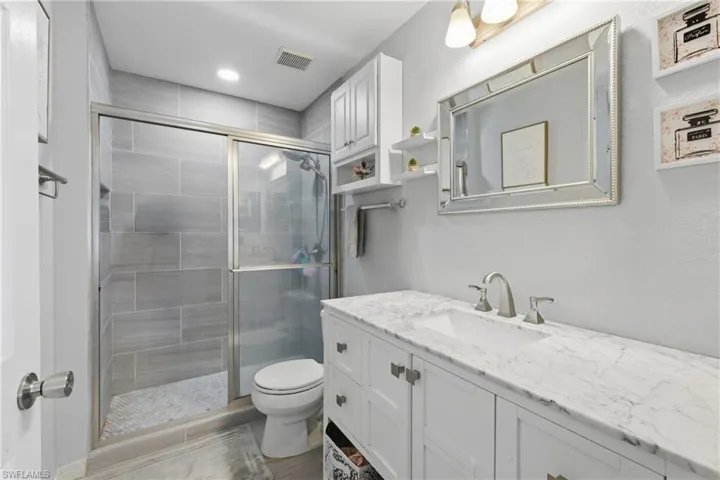 Full bath featuring vanity and a shower stall