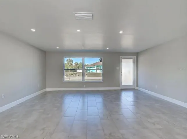 Empty room with baseboards and recessed lighting