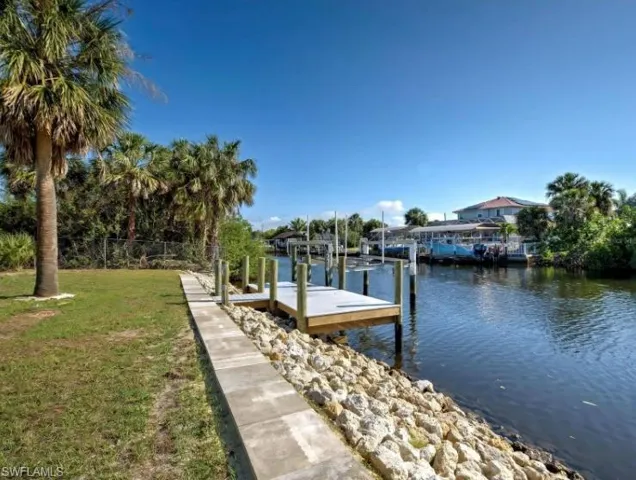 Dock with a water view, a lawn, and boat lift