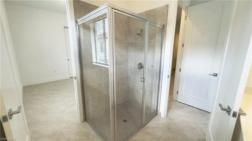 Bathroom with a stall shower and light tile patterned floors