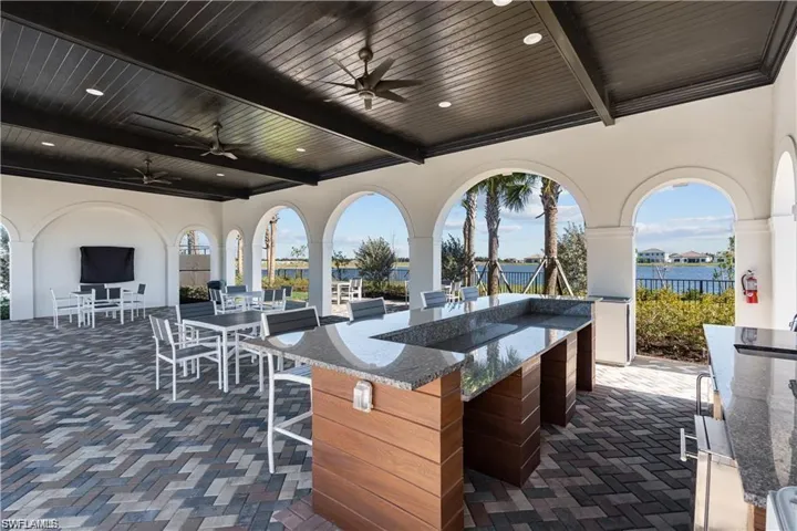 View of patio featuring a ceiling fan, a water view, and outdoor dining area