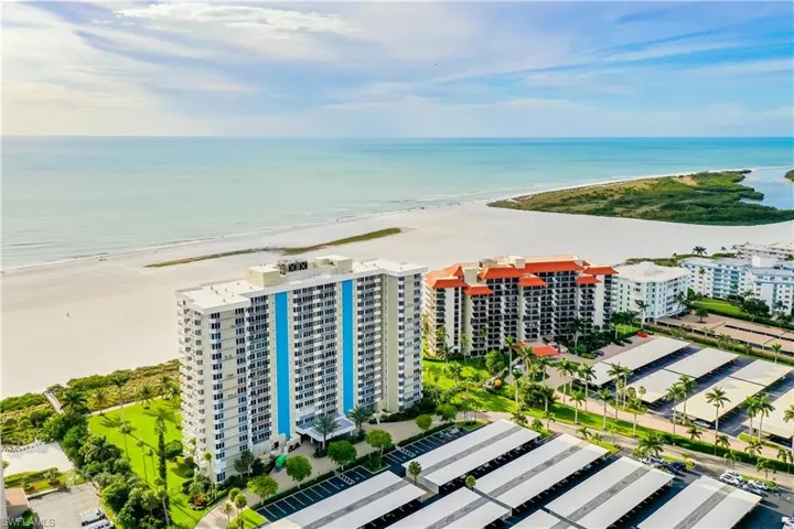 Drone / aerial view of apartment complex / building and waterfront with a beach
